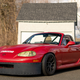 A photo of a track-ready Mazda Miata in red.